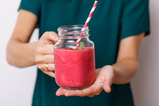Young woman offer detox drink, smoothie in glass jar.
