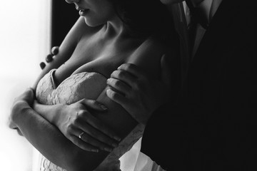 Obraz premium Groom holds shoulders of a sensetive bride