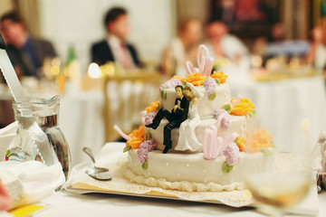 Figures of newlyweds sit on the tasty  wedding cake