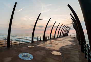 View of ships on Indian Ocean through the Millenium Pier in Umhlanga Rocks at sunrise - obrazy, fototapety, plakaty