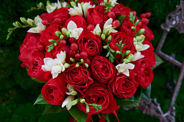 dense red bouquet of roses, with red berries and decor. Close