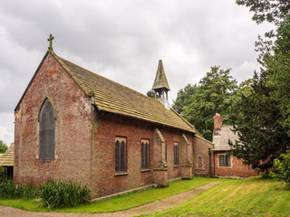 Fototapeta na wymiar Styal, Cheshire, UK. July 26th 2016. Quintessential english village church in Styal village on a cloudy summer day, Styal, Cheshire, UK