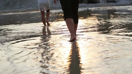 Couple walk along lake sand beach to the water - Powered by Adobe