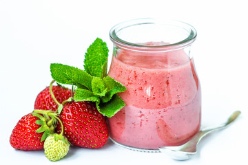 Smoothie or milkshake in glass jar with fresh strawberry fruits and mint isolated on white background, healthy food for breakfast and snack. Health and diet concept, close up.
