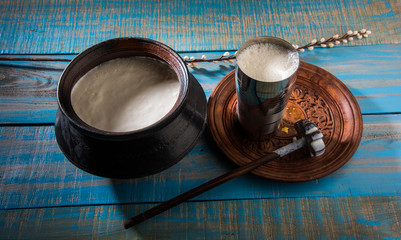 Indian sweet Lassi made up of milk, curd, sugar and salt mixed with ice cubes, served in a jumbo steel glass, prepared in traditional earthen pot - obrazy, fototapety, plakaty