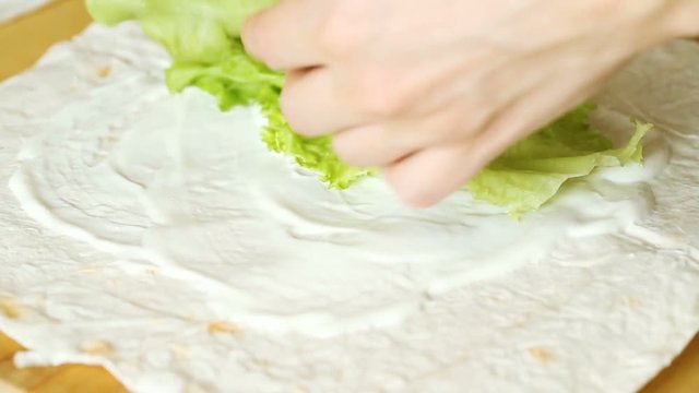 Amateur female cooker making caesar chicken roll, close up video