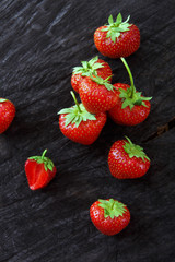 Red fresh strawberries on black rustic wood background