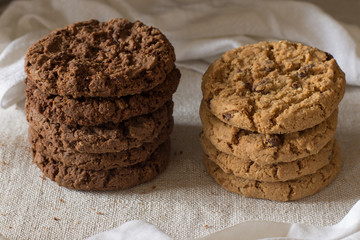 Cookies pile with chocolate chip on light textile background. Delicious morning snacks for breakfast, brunch and lunch. Appetizing, healthy and fast food
