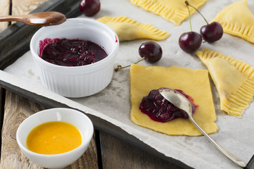 Raw ingredients for homemade cakes with cherry on a dark wooden background. Rustik style. Selective focus.