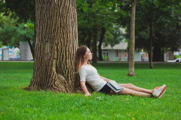 Girl with book under tree