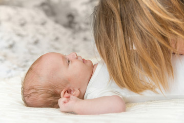 Smiling newborn baby and mother