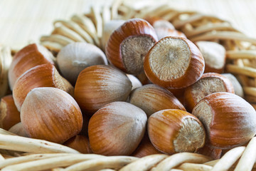 Closeup of hazelnuts in weaved baskets on bright wooden background