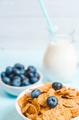 healthy breakfast, cornflakes blueberry and milk, nuts, almond with text space top view close-up instagram filter