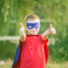  Kid in super hero costume showing thumbs up.