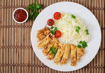 Fried pork cutlet with fresh cabbage salad and sauce. Top view
