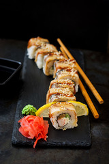 Traditional Japanese food - sushi, rolls and sauce on a black background.