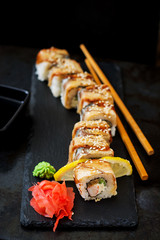 Traditional Japanese food - sushi, rolls and sauce on a black background.