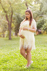 young happy pregnant woman relaxing and enjoying life in nature

