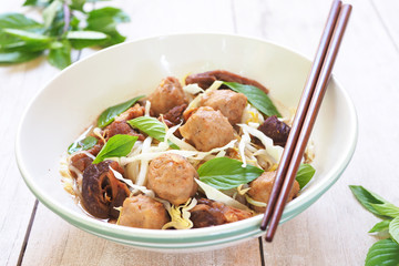 Close up of beef noodle soup with meatballs on a wooden backgrou