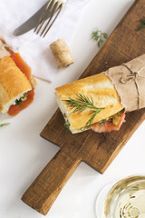 Tasty sandwiches with smoked salmon over white table