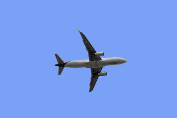 Closeup of the below of the plane that was flying up isolated on blue background.