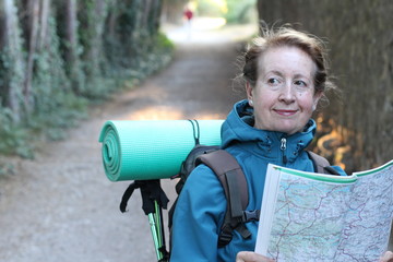 Woman standing reading map on hike in the countryside