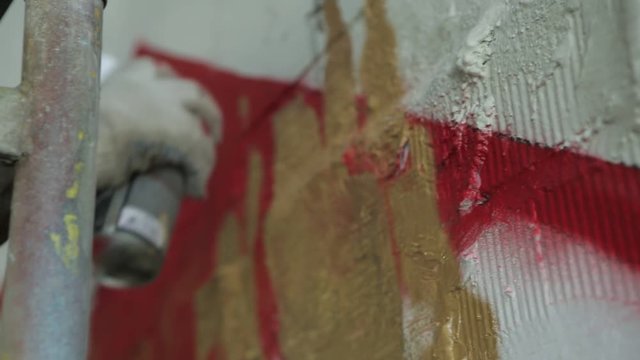 Handheld Shot of an Artist Spraying Paint on the Wall. Urban Lifestyle and Street Art Concept. Outdoor Handheld Shot.