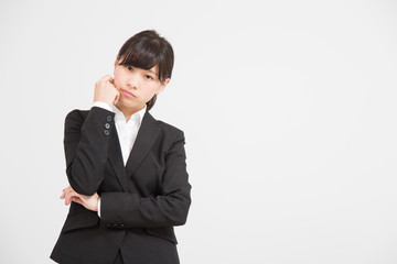 悩むスーツの女性