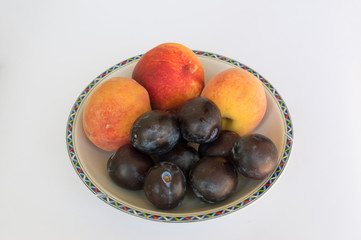 Fresh fruit, peaches and plums isolated on white background