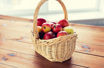 close up of basket with apples on wooden table