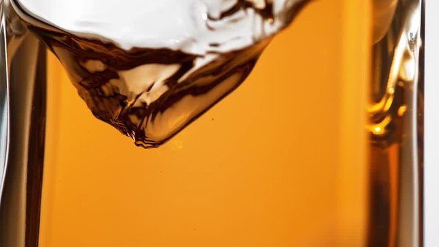 Brown liquid in glass bottle spinning. Shot with high speed camera, phantom flex 4K.  Slow Motion. 