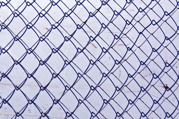 Fototapeta premium abstract chain link fence texture against grungy color wall.