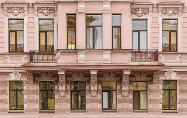 Several windows in a row and bay window on facade of urban apartment building front view, St. Petersburg, Russia.