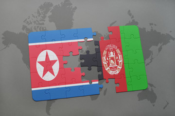 puzzle with the national flag of north korea and afghanistan on a world map background.