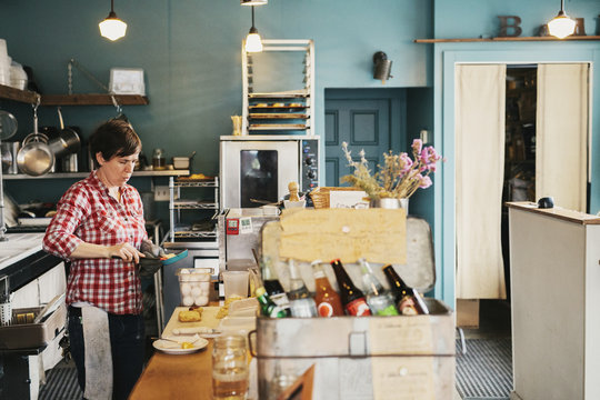 A woman working behind the counter in a coffee shop. Business owner. 