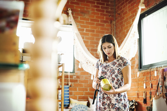Young woman in a shop, scanning the barcode of a candle with a barcode scanner.