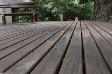 a wooden deck under a tree with a chair