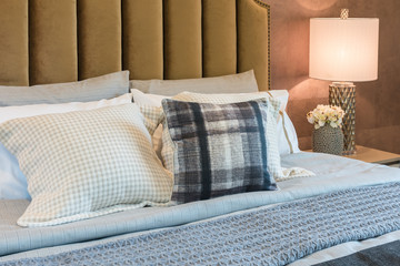luxury bedroom with set of pillows on bed and white lamp