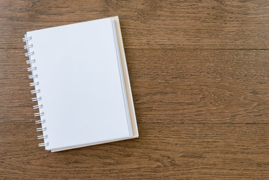 blank white notebook on wooden texture background