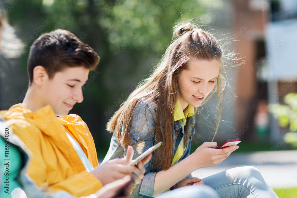 Sticker happy teenage friends with gadgets outdoors