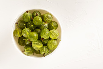 Bowl of gooseberries over white table