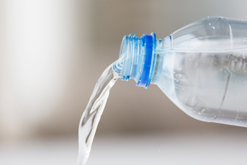 close up of water pouring from plastic bottle