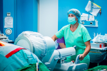 Medical assistant with a c-arm fluoroscope verifying spine surge