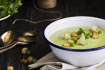 Green spinach and pea soup with croutons