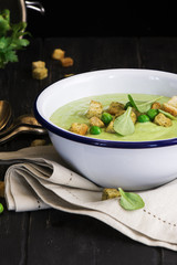 Green spinach and pea soup with croutons