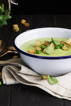 Green spinach and pea soup with croutons