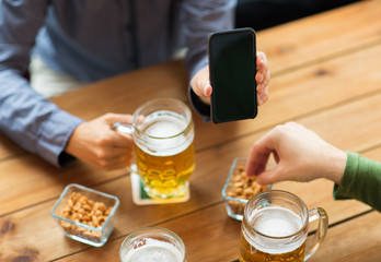 close up of friends with smartphone and beer