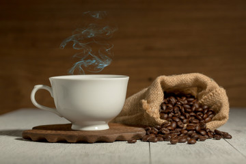 Coffee cup and coffee beans on wooden background