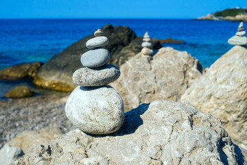 Small pyramids are on the big rocks by the Black sea.