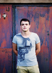 young happy man against rusty metal wall